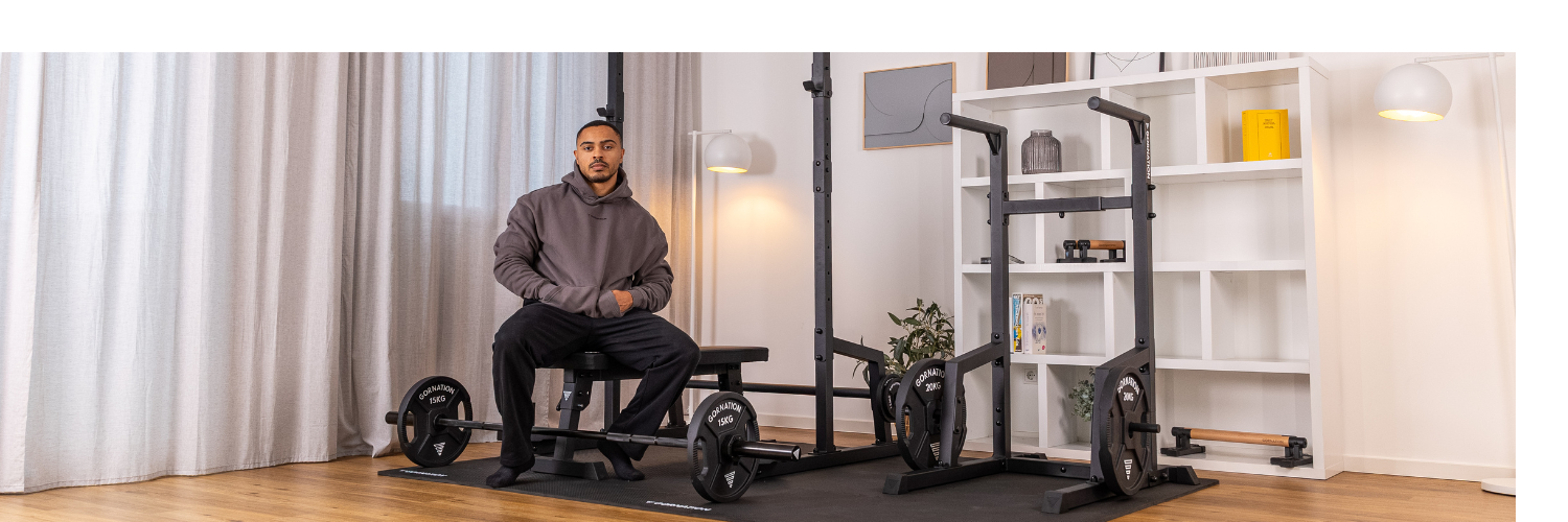GORNATION athlete sitting in front of a complete home workout set up from GORNATION