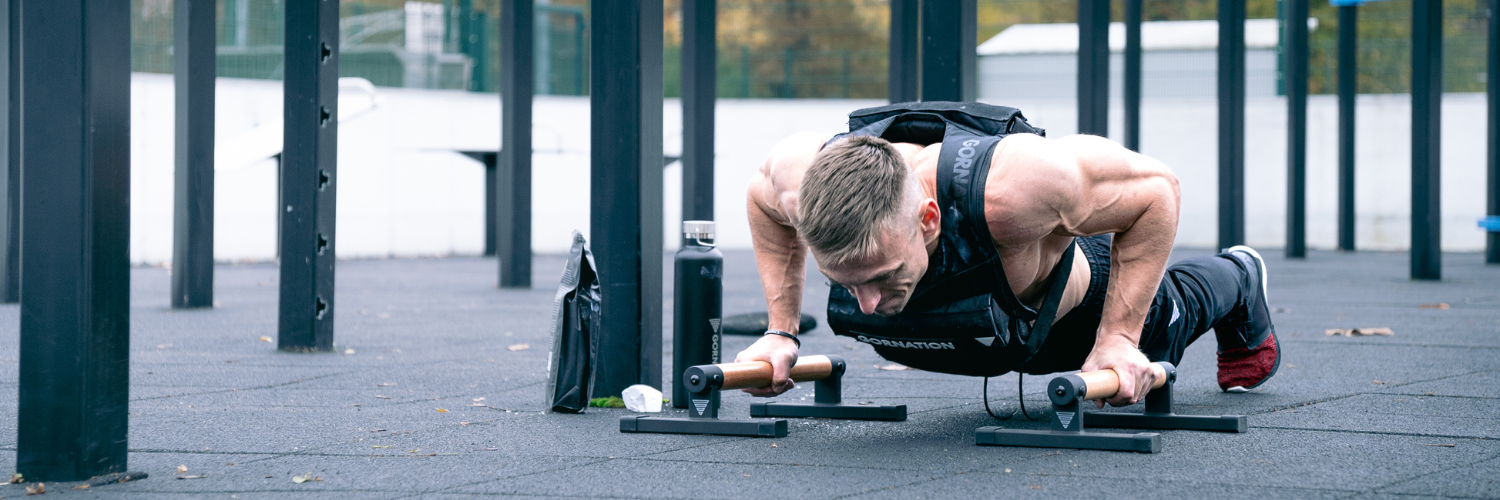 GORNATION athlete doing a push up in a park with the GORNATION weight west