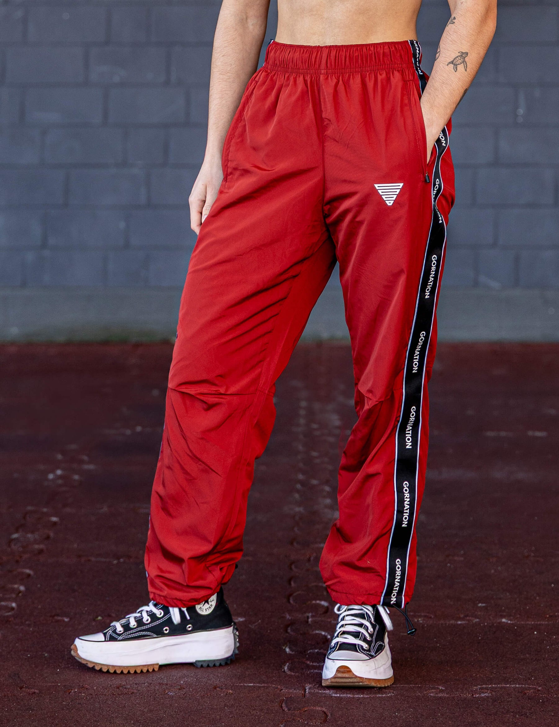 GORNATION athlete wearing the GORNATION tracksuite pants in red