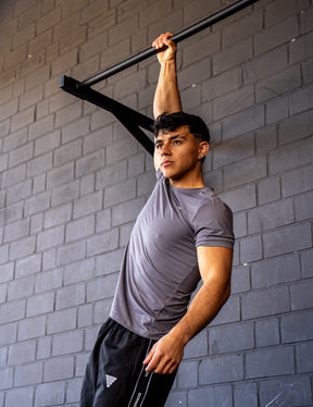 GORNATION athlete hanging on a GORNATION pull up bar wearing an active t-shirt