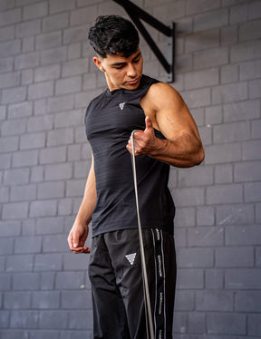 GORNATION athlete doing bicep curls with a GORNATION resistance band wearing an active tank top 