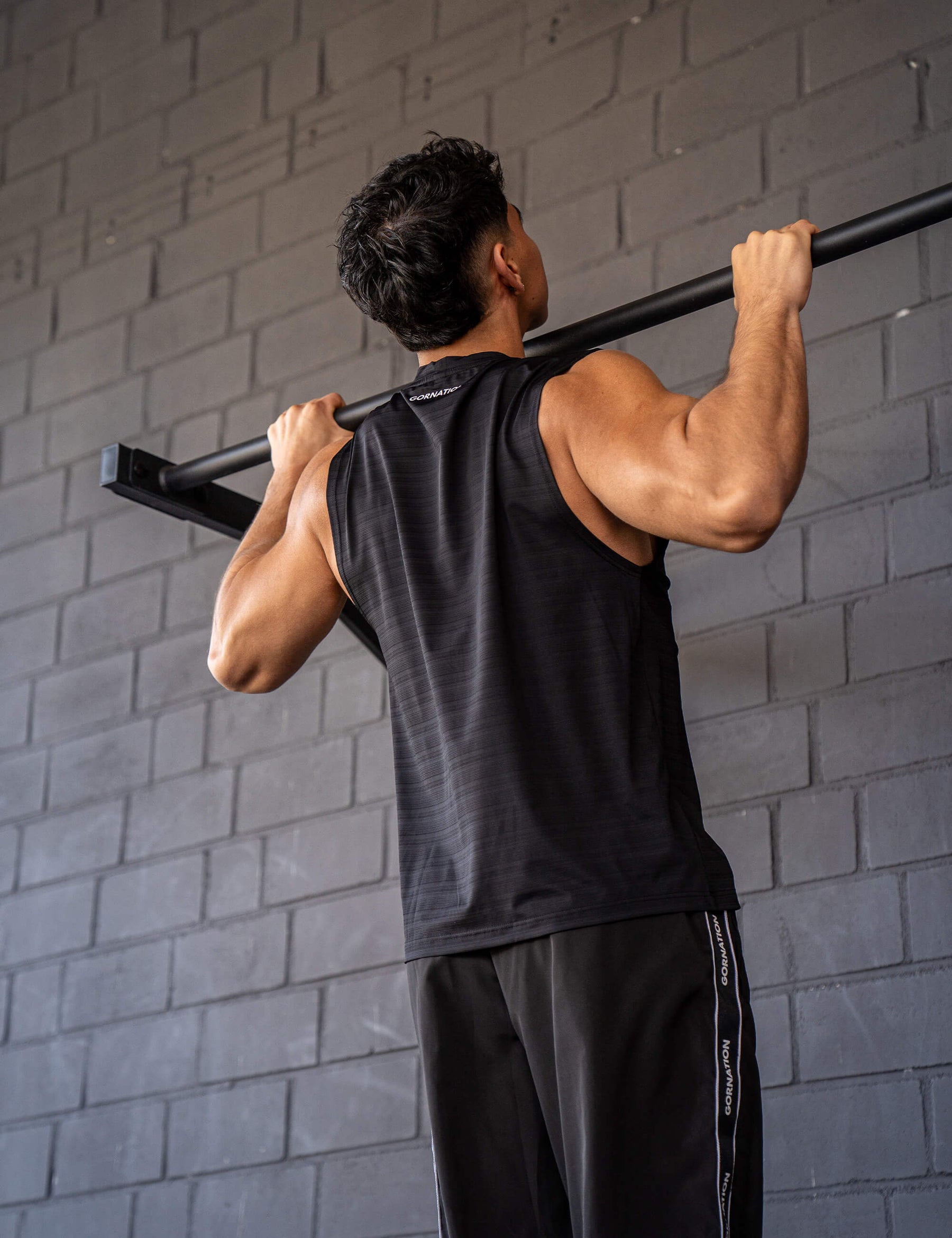 GORNATION athlete doing pull ups with a GORNATION pull up bar wearing an active tank top 