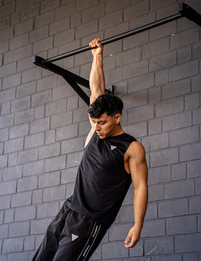 GORNATION athlete hanging on a GORNATION pull up bar wearing an active tank top 