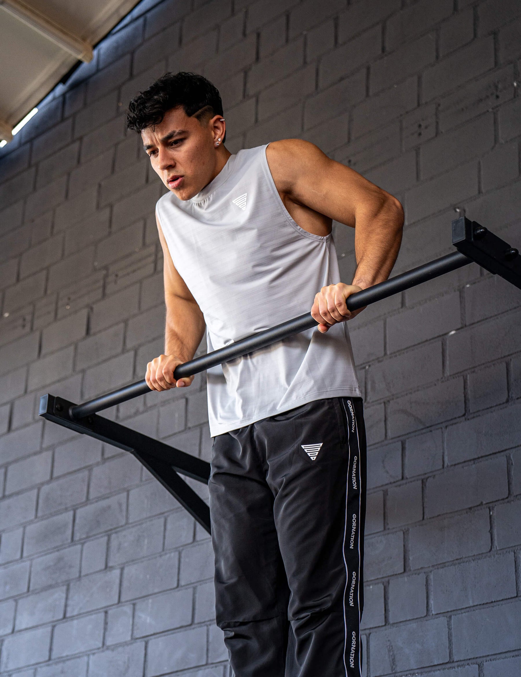 GORNATION athlete doing muscle ups with a GORNATION pull up bar wearing an active tank top 