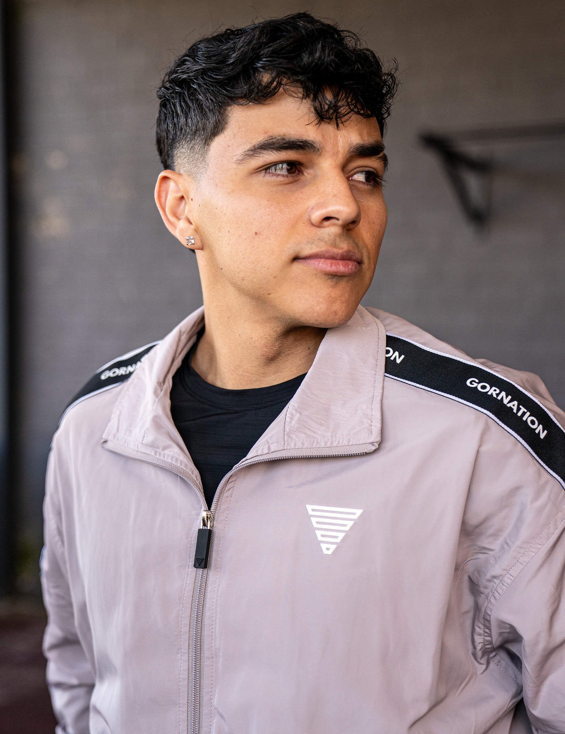 Close up of a GORNATION athlete wearing the GORNATION tracksuite jacket in grey
