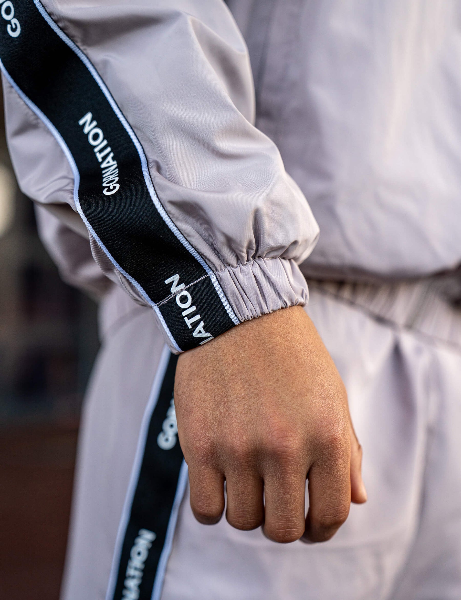 Close up of a GORNATION athlete wearing the GORNATION tracksuite jacket in grey