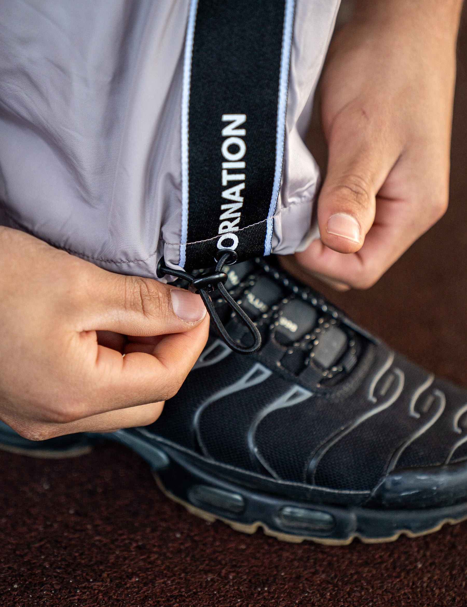 Close up of a GORNATION athlete wearing the GORNATION tracksuite pants in grey