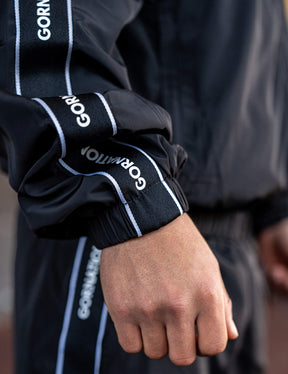 Close up of a GORNATION athlete wearing the GORNATION tracksuite jacket in black