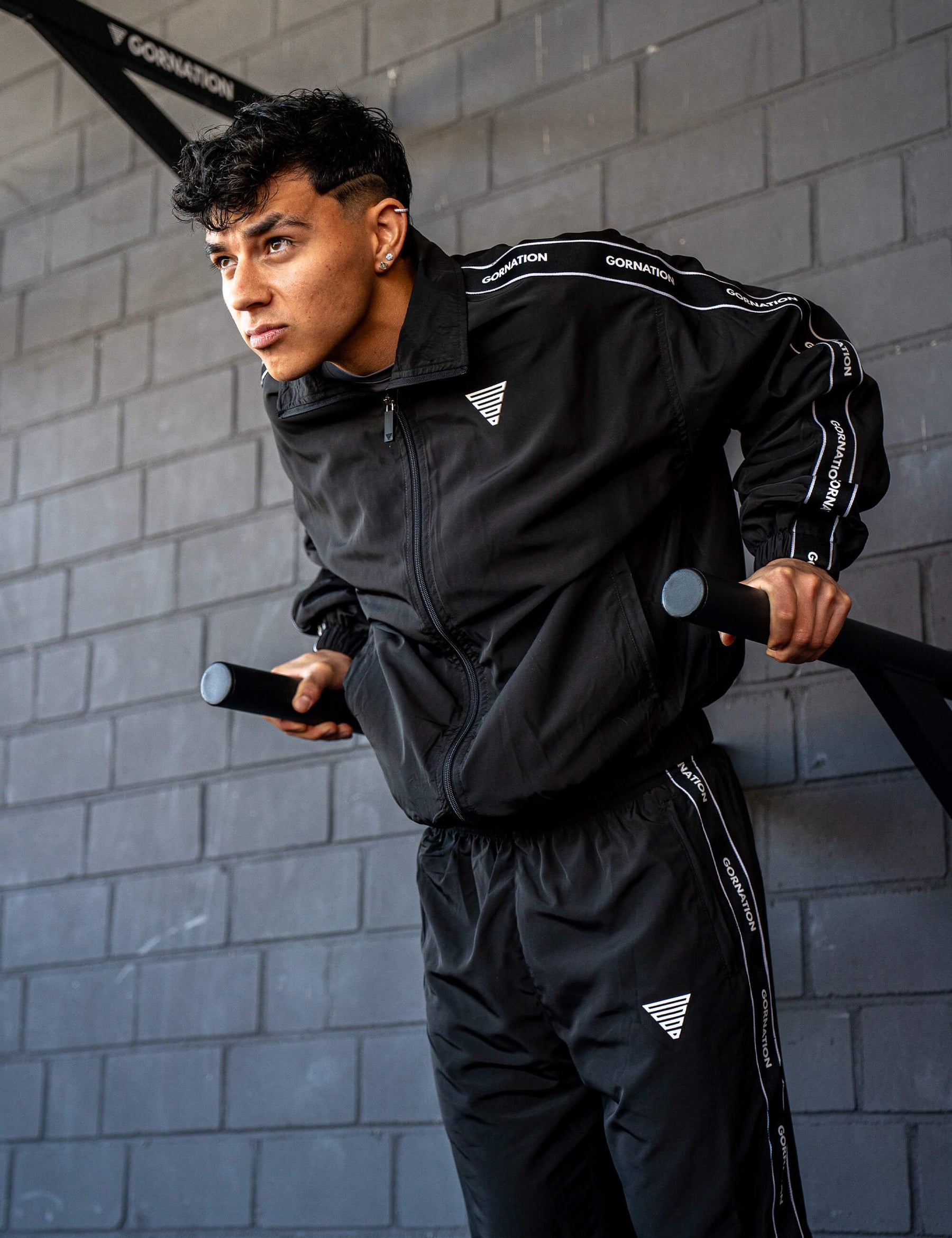 GORNATION athlete doing dips on GORNATION dip bars wearing a tracksuite