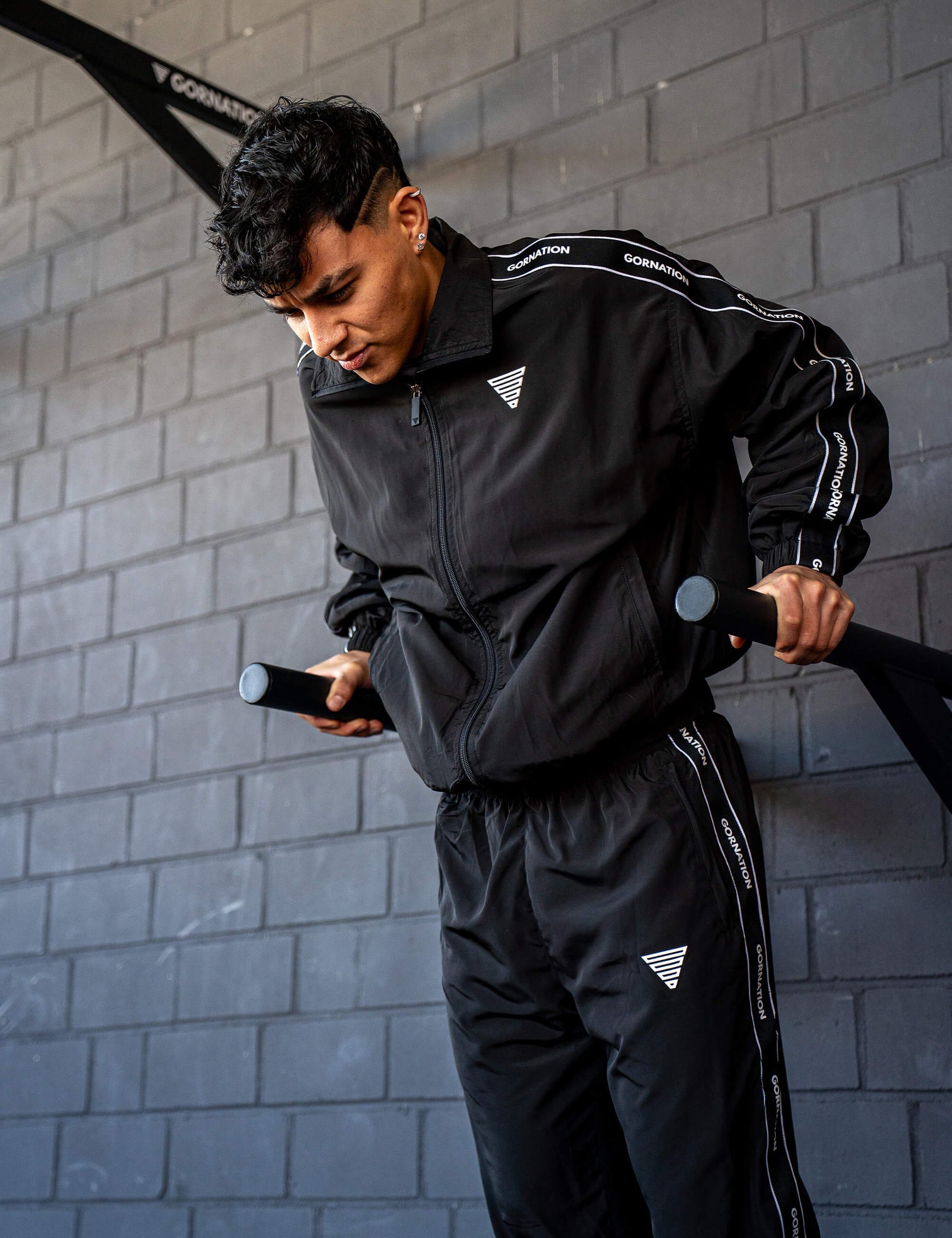 GORNATION athlete doing dips on GORNATION dip bars wearing a tracksuite