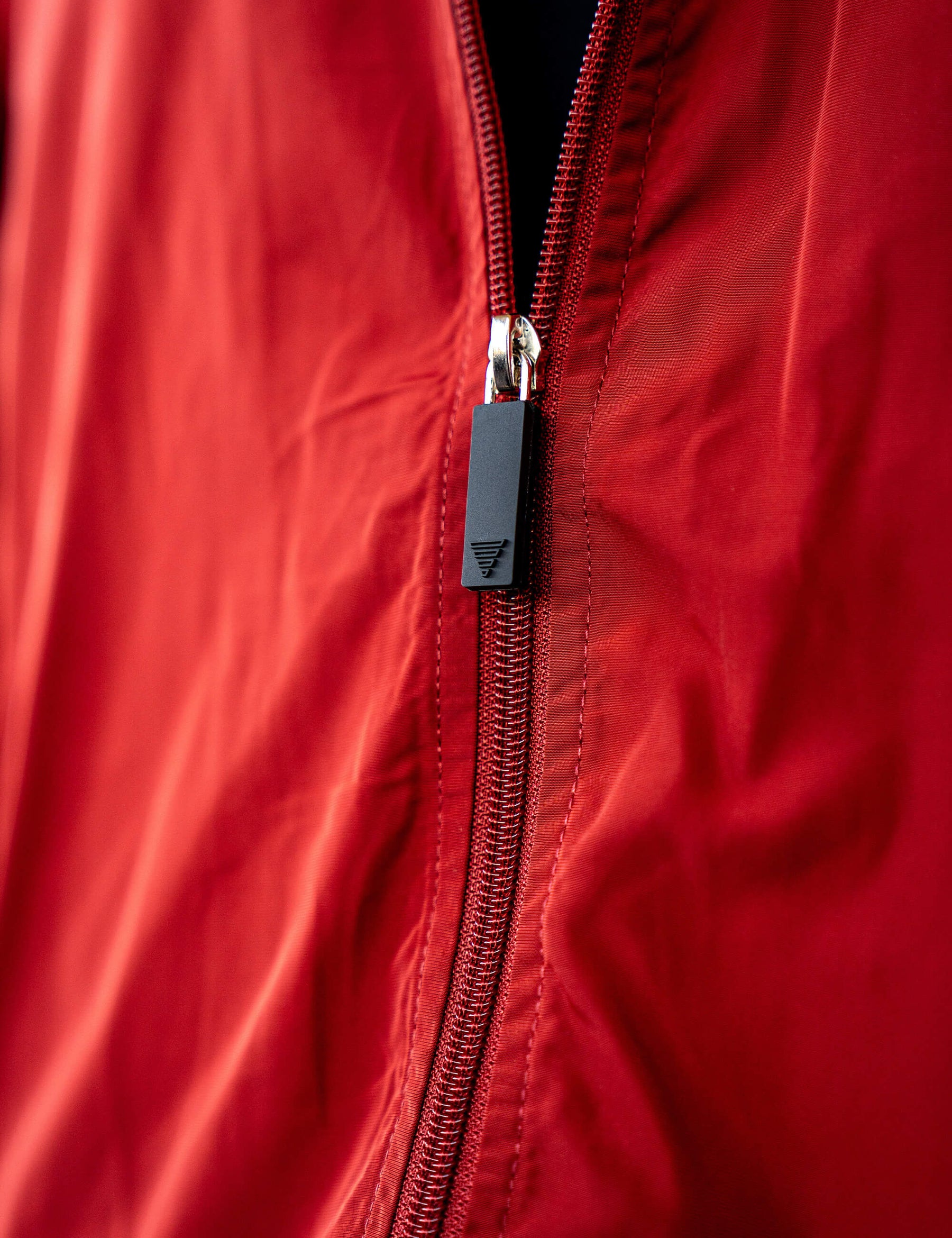 Close up of a GORNATION athlete wearing the GORNATION tracksuite jacket in red