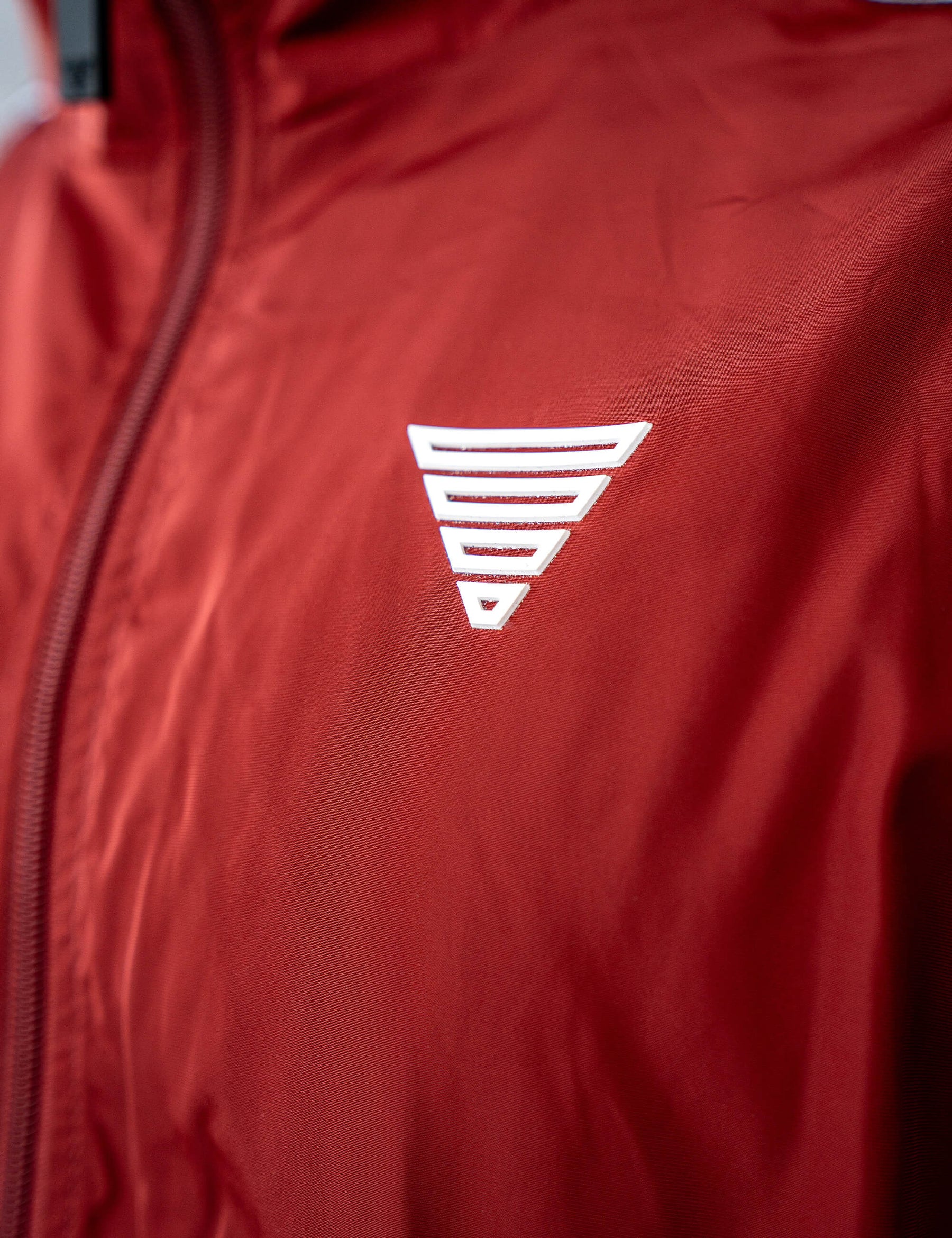 Close up of a GORNATION athlete wearing the GORNATION tracksuite jacket in red