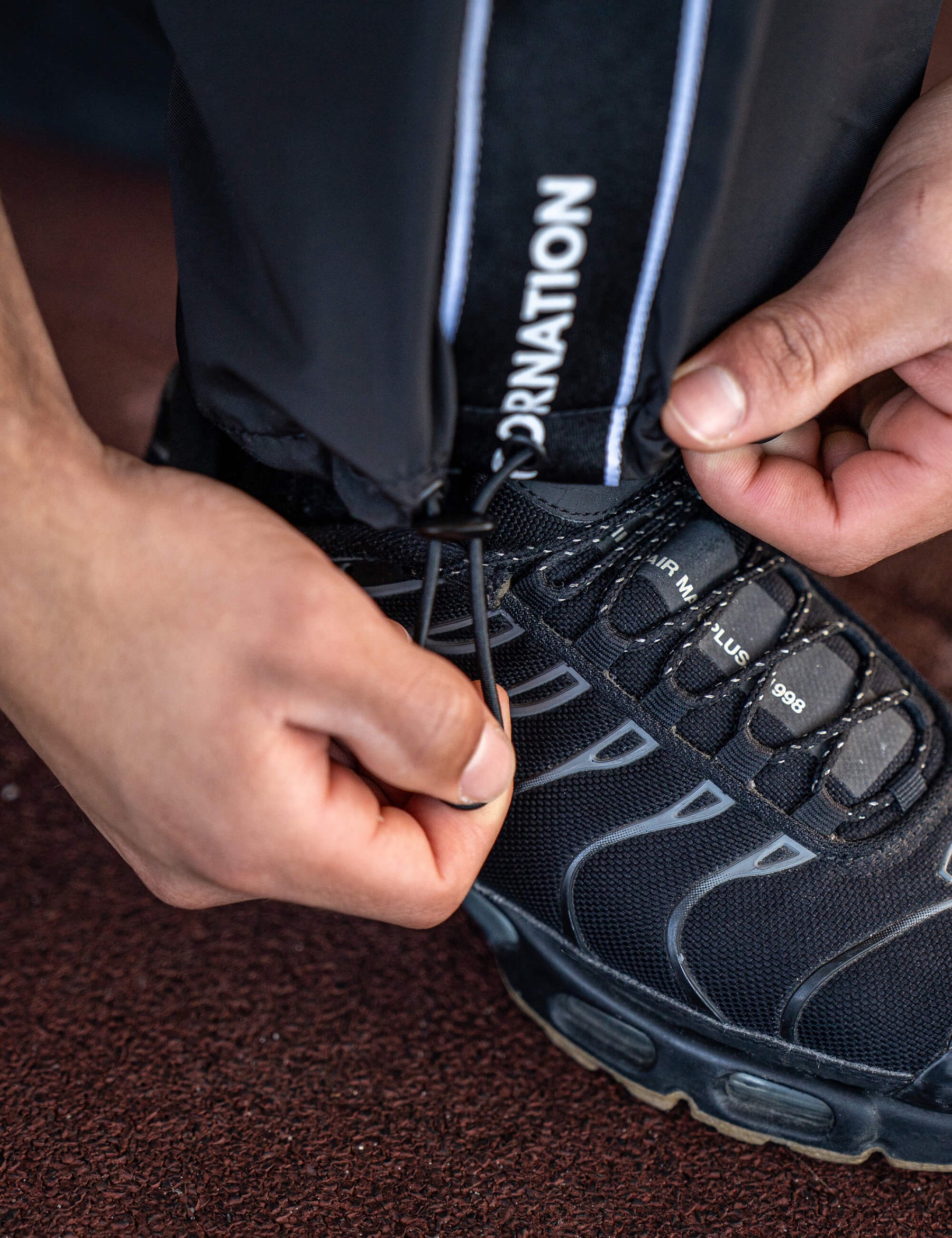 Close up of a GORNATION athlete wearing the GORNATION tracksuite pants in black