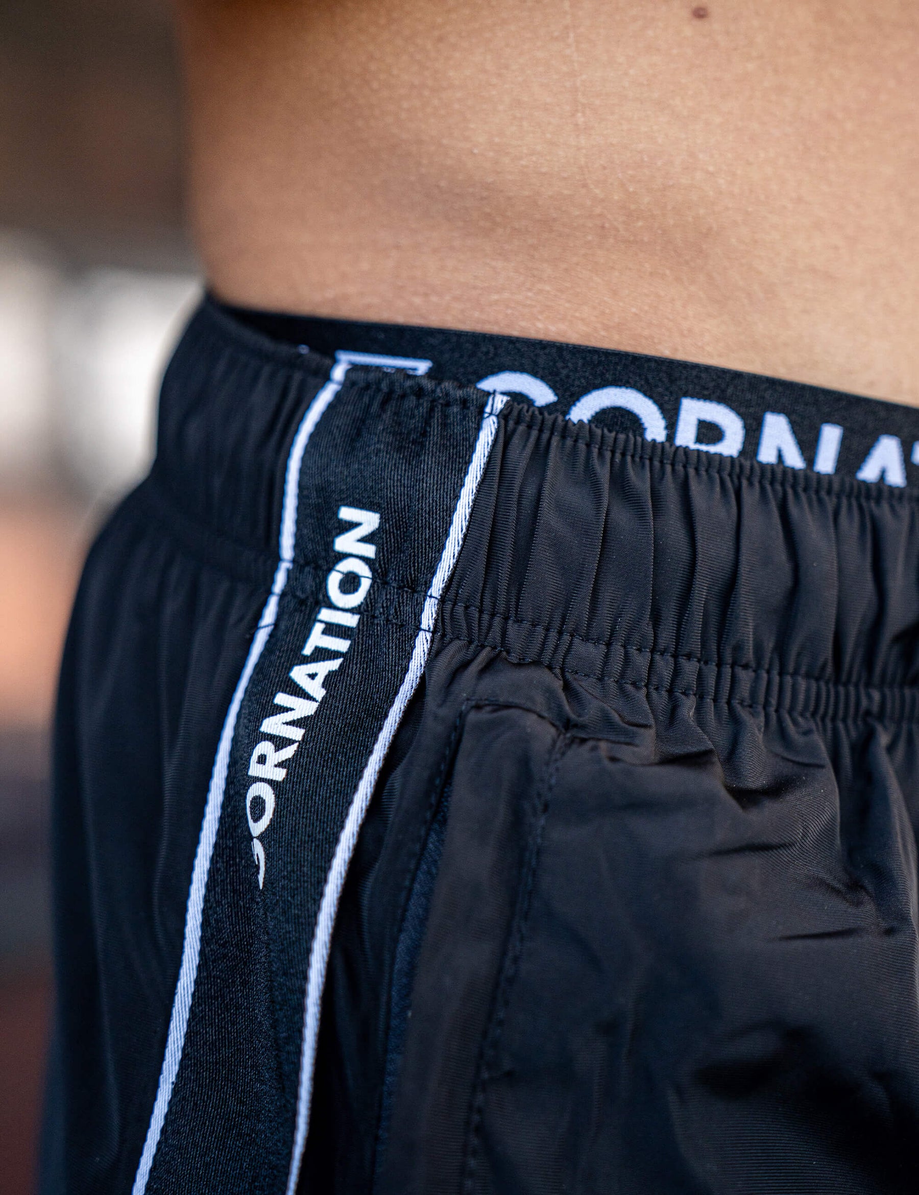 Close up of a GORNATION athlete wearing the GORNATION tracksuite pants in black