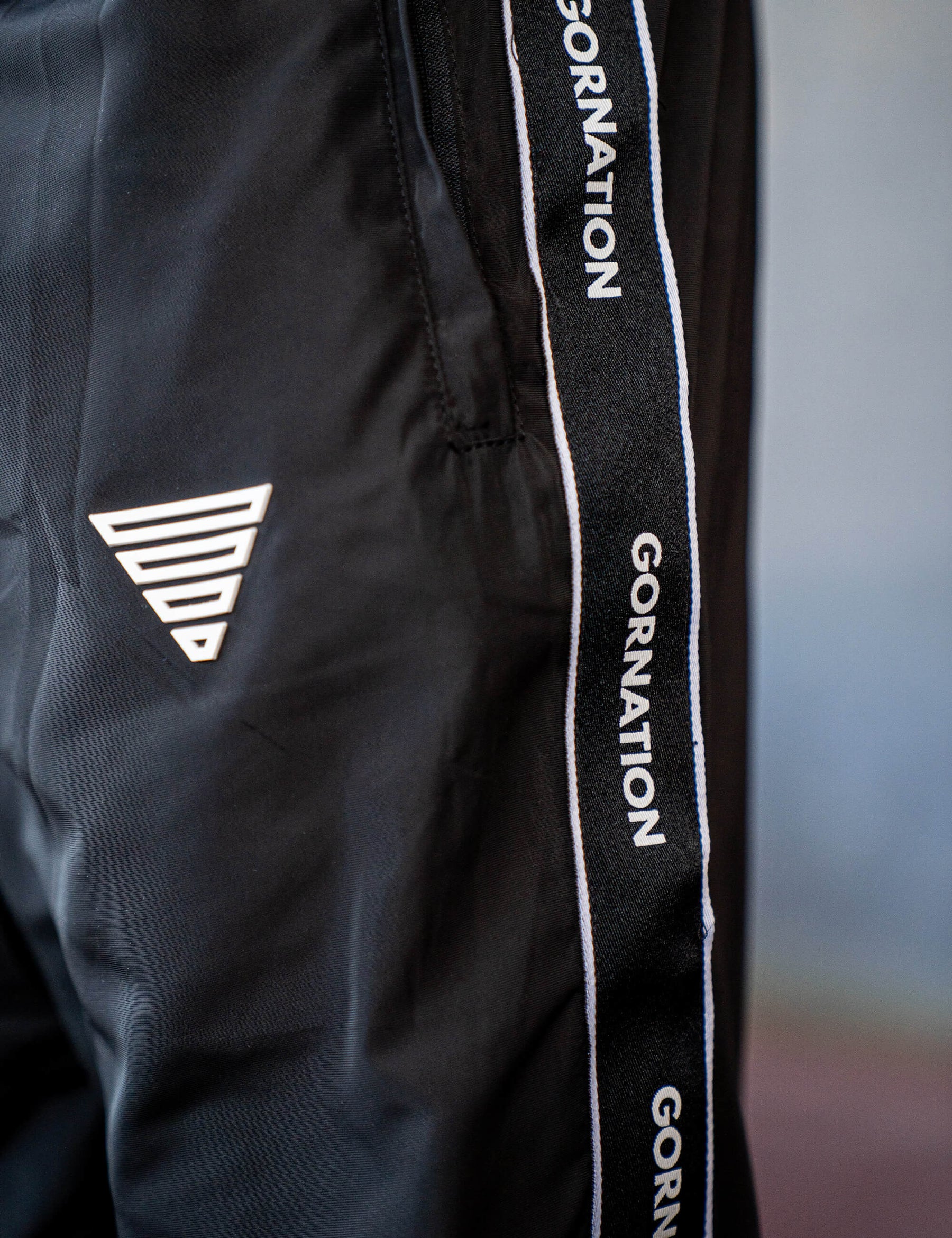 Close up of a GORNATION athlete wearing the GORNATION tracksuite pants in black