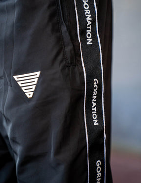 Close up of a GORNATION athlete wearing the GORNATION tracksuite pants in black