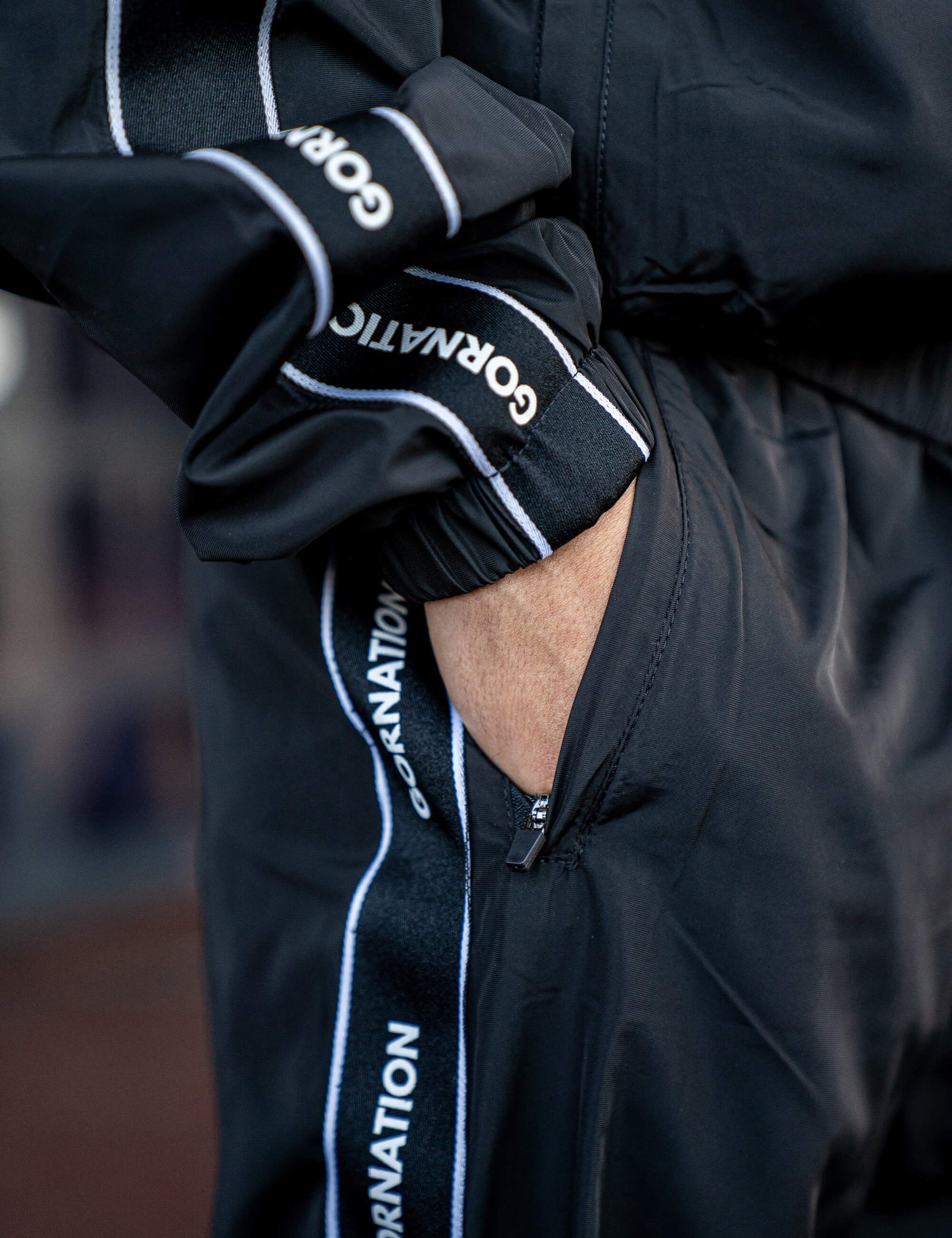 Close up of a GORNATION athlete wearing the GORNATION tracksuite pants in black