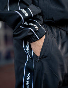 Close up of a GORNATION athlete wearing the GORNATION tracksuite pants in black