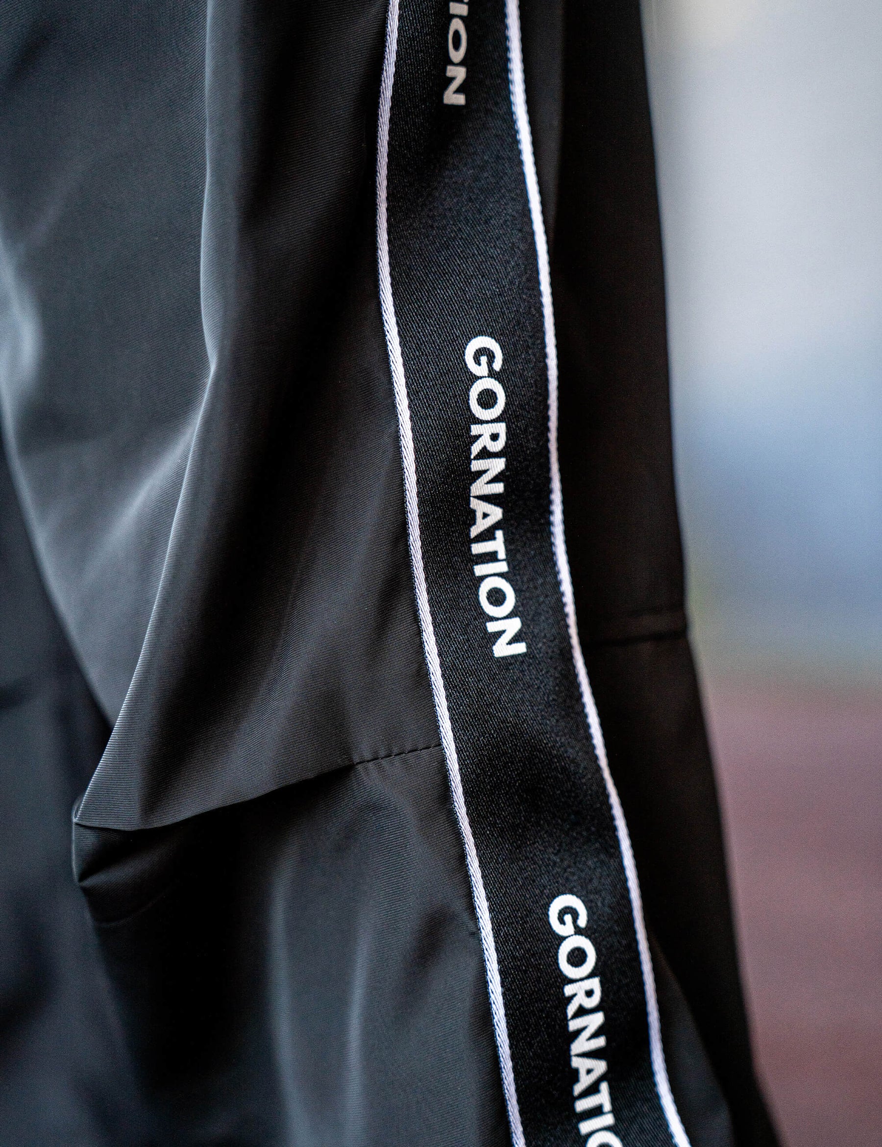 Close up of a GORNATION athlete wearing the GORNATION tracksuite pants in black