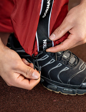 Close up of a GORNATION athlete wearing the GORNATION tracksuite pants in red