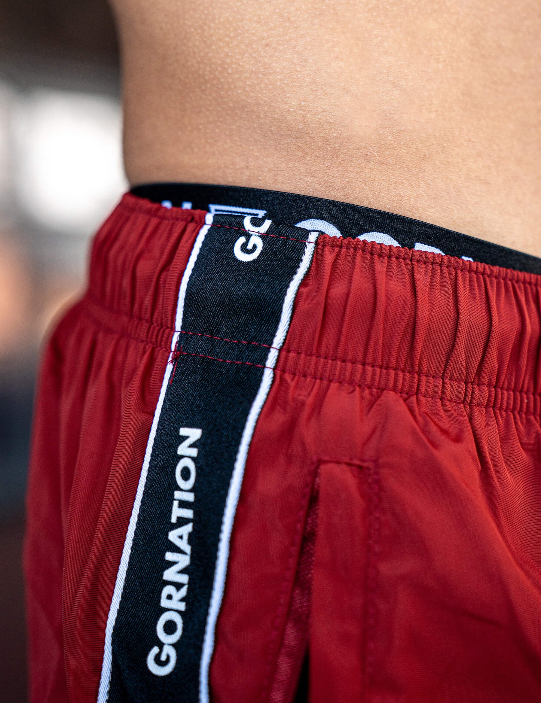 Close up of a GORNATION athlete wearing the GORNATION tracksuite pants in red