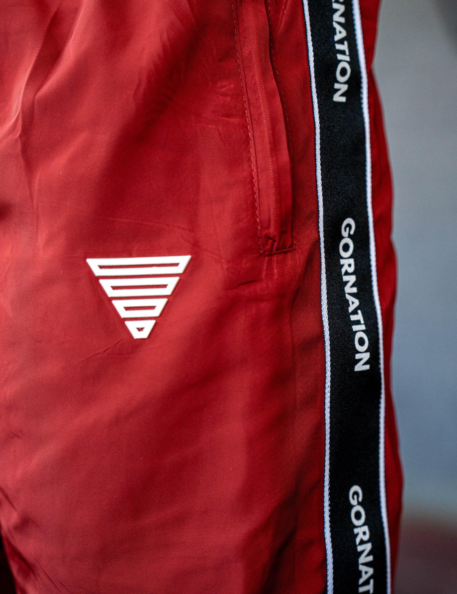 Close up of a GORNATION athlete wearing the GORNATION tracksuite pants in red