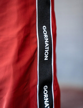 Close up of a GORNATION athlete wearing the GORNATION tracksuite pants in red