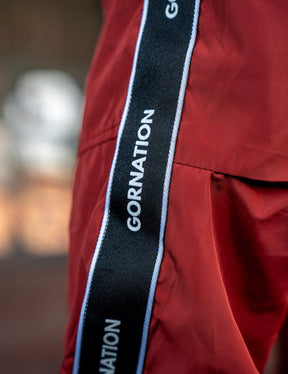 Close up of a GORNATION athlete wearing the GORNATION tracksuite pants in red
