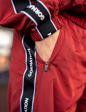 Close up of a GORNATION athlete wearing the GORNATION tracksuite pants in red